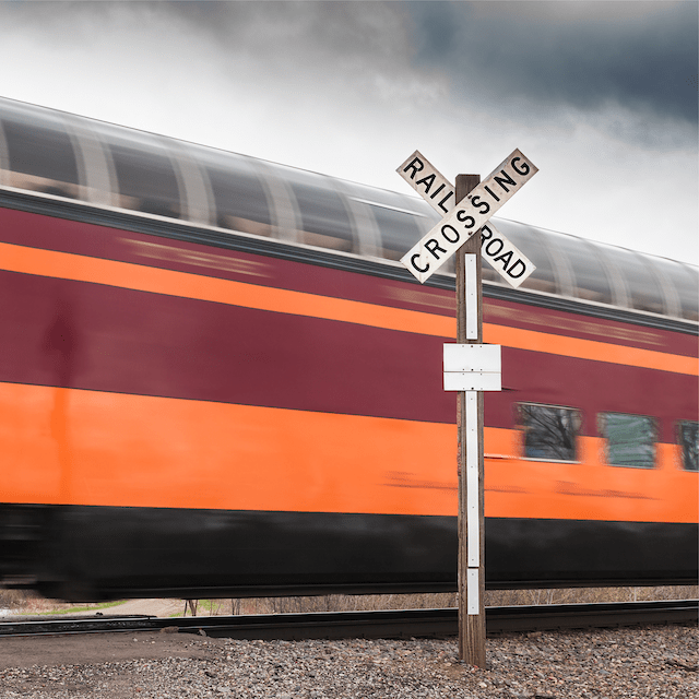 Moving train passing by rail crossing sign